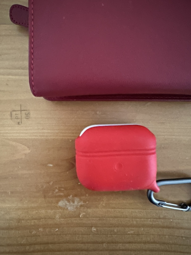 A red purse and a red AirPods case. 